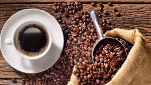 cup of coffee and roasted beans on wood table uhd 4k wallpaper